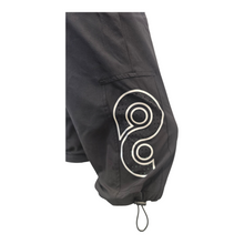 Load image into Gallery viewer, Black shorts with a white logo on a white background